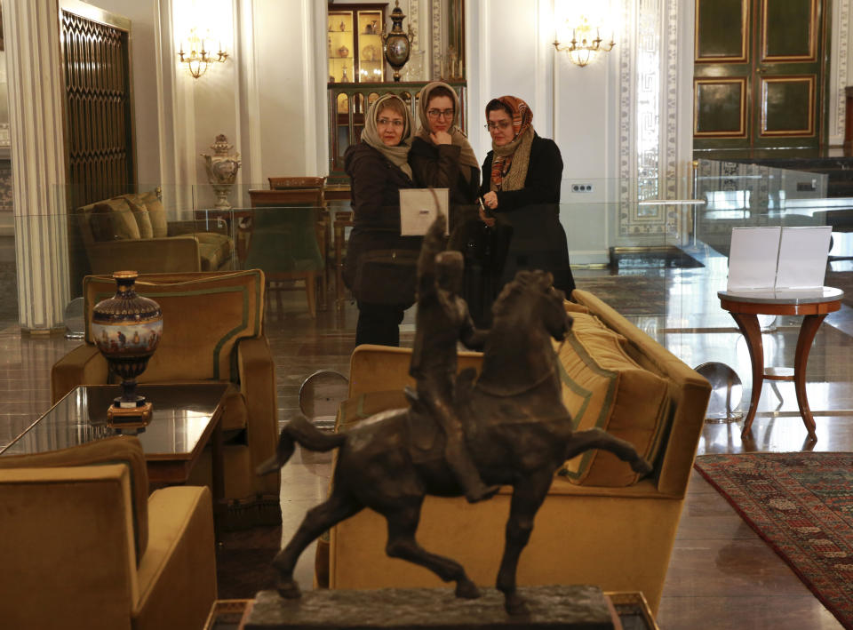 In this Tuesday, Jan. 15, 2019 photo, people visit Niavaran Palace, now a museum, that was the primary and last residence of late Shah Mohammad Reza Pahlavi and his family prior to leaving Iran for exile during the 1979 Islamic Revolution, in northern Tehran, Iran. The palace complex of mansions on a 27-acre plot, nestled against the Alborz Mountains, now welcomes the public to marvel at the luxuries the shah enjoyed as Iran's monarch for nearly four decades. It costs about $1 to enter. (AP Photo/Vahid Salemi)