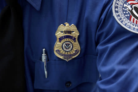 FILE PHOTO: A Transportation Security Administration (TSA) official wears a TSA badge at Terminal 4 of JFK airport in New York City, U.S., May 17, 2017. REUTERS/Joe Penney/File Photo