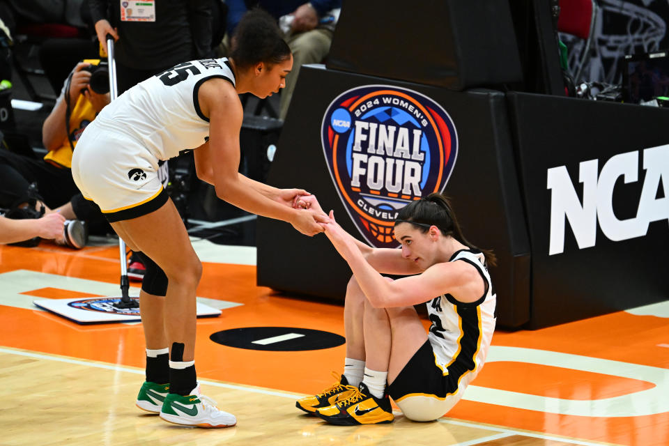 Iowa's Hannah Stuelke helps up Caitlin Clark during their win over UConn on Friday. (Jason Miller/Getty Images)