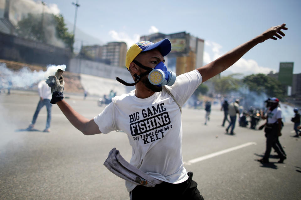 An opposition demonstrator throws back a tear gas canister on a street near the Generalisimo Francisco de Miranda Airbase "La Carlota" in Caracas, Venezuela April 30, 2019. (Photo: Ueslei Marcelino/Reuters)