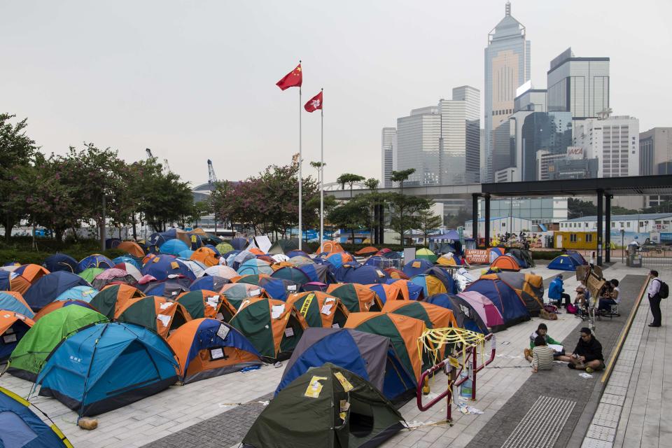 The flags of China (L) and Hong Kong are seen above tents outside Legislative Council Complex at an occupied area in Hong Kong November 11,2014. Hong Kong's acting chief executive on Tuesday called on pro-democracy protesters to clear sites they have occupied for more than six weeks and warned holdouts they could face arrest, a move that could swell protest numbers. REUTERS/Tyrone Siu (CHINA - Tags: POLITICS CIVIL UNREST)