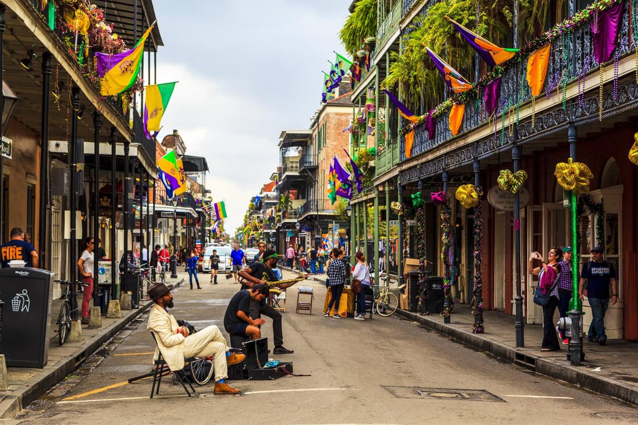 local jazz band performs in the New Orleans French Quarter with visitors in background