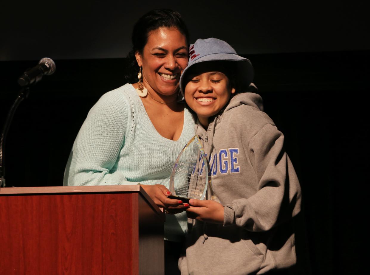 Jeyla Luvert, 17, right, receives the MLK Team Community Service Award from Niyah Ross during a gathering at the Shedd Institute on Feb. 19 after a makeup Dr. Martin Luther King Jr. March.