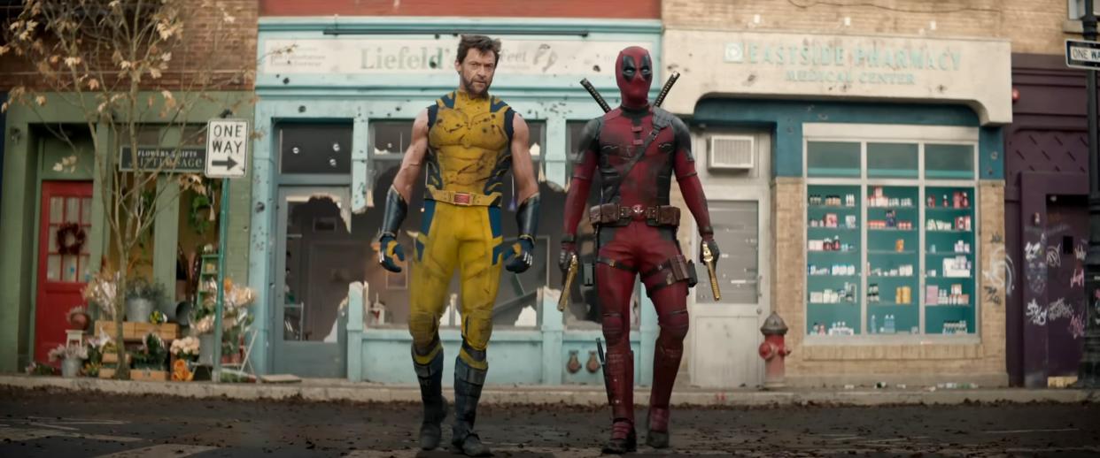 Hugh Jackman as Wolverine and Ryan Reynolds as Deadpool walk across a street.