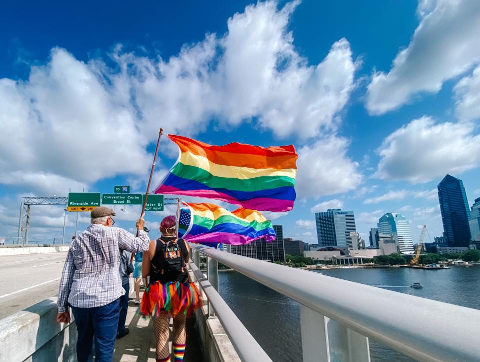Hundreds of people from Jacksonville's LGBTQ community and their supporters — many with rainbow flags — marched across the Acosta Bridge in June 2021 after the state Department of Transportation ordered a halt to Pride lighting on the bridge and then reversed that decision by allowing the lighting to resume for its week-long display.