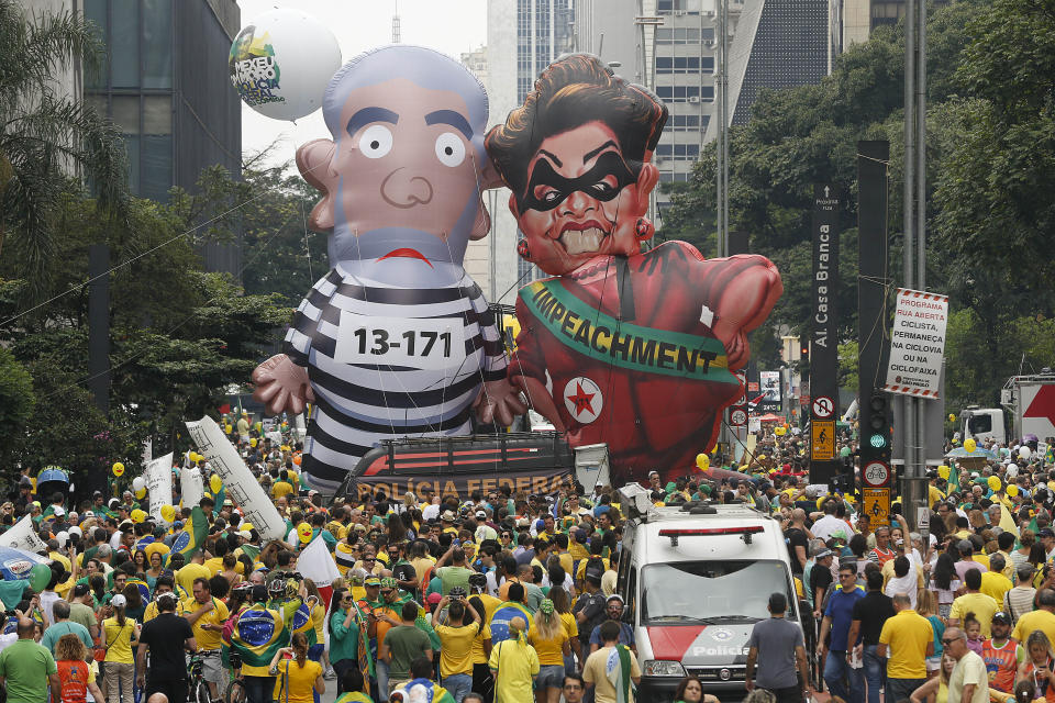 FILE - Demonstrators parade large inflatable dolls depicting Brazil's former President Luiz Inacio Lula da Silva in prison garb and current President Dilma Rousseff dressed as a thief, with a presidential sash that reads "Impeachment," in Sao Paulo, Brazil, March 13, 2016. (AP Photo/Andre Penner, File)