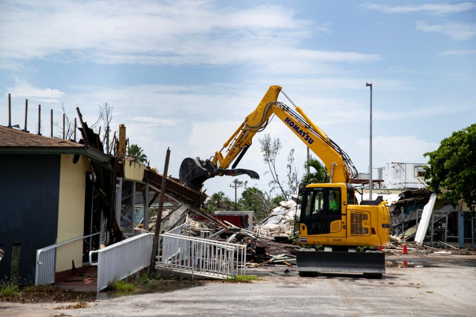 Excavators tear down the shops by Bailey's General Store and remove the debris on Friday, July 21, 2023. The demolition project will also include the main Bailey's building.