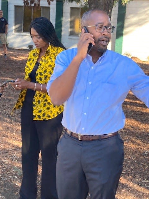 Oakland City Councilmembers Treva Reid, left, and Loren Taylor, right, gather outside the family reunification center after a nearby school shooting left six people injured.