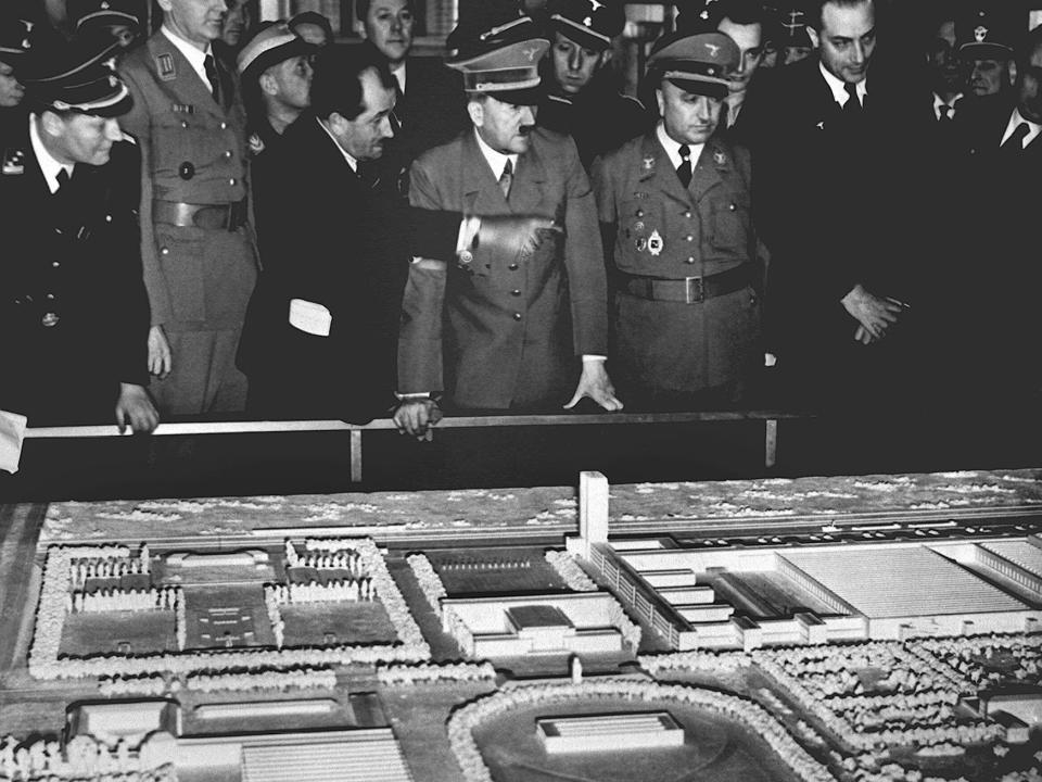 Adolf Hitler overlooks a model of the Volkswagen factory and 'Kraft-durch-Freude-Stadt' city.