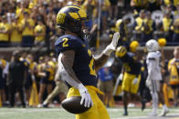 Michigan running back Blake Corum (2) celebrates an 11-yard touchdown against Connecticut by holding up five fingers in the second half of an NCAA college football game in Ann Arbor, Mich., Saturday, Sept. 17, 2022. Corum ran for five touchdowns in the game. (AP Photo/Paul Sancya)