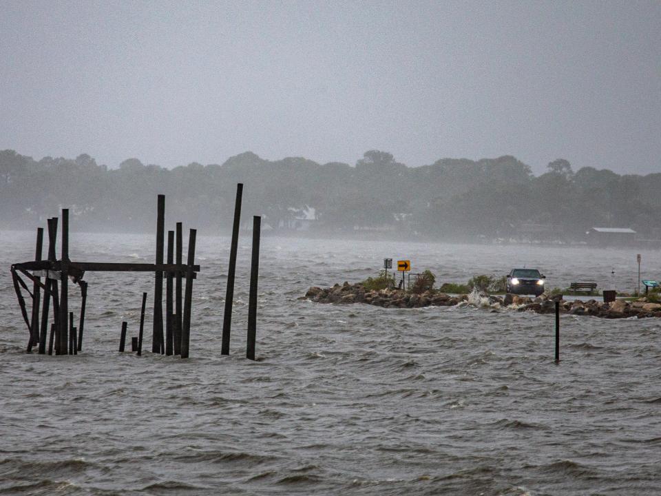 A car drives along the waterfront as Tropical Storm Elsa makes landfall on 7 July 2021 in Cedar Key (Getty Images)