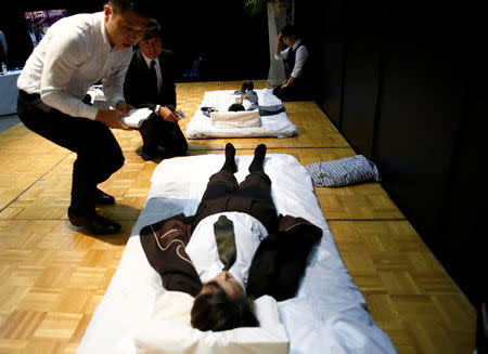 Judges check a model after a funeral undertaker dressed up the model, during an encoffinment competition at Life Ending Industry EXPO 2017 in Tokyo, Japan August 24, 2017. REUTERS/Kim Kyung-Hoon