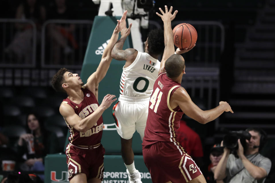 Miami guard Chris Lykes (0) is fouled by Boston College guard Derryck Thornton, left, as forward Steffon Mitchell (41) defends during the first half of an NCAA college basketball game, Wednesday, Feb. 12, 2020, in Coral Gables, Fla. (AP Photo/Lynne Sladky)