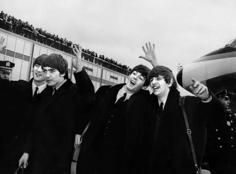 De izquierda a derecha, John Lennon, George Harrison, Paul McCartney y Ringo Starr, integrantes de los Beatles, saludan a su llegada al aeropuerto John F. Kennedy de Nueva York, el 7 de febrero del año 1964 (-)