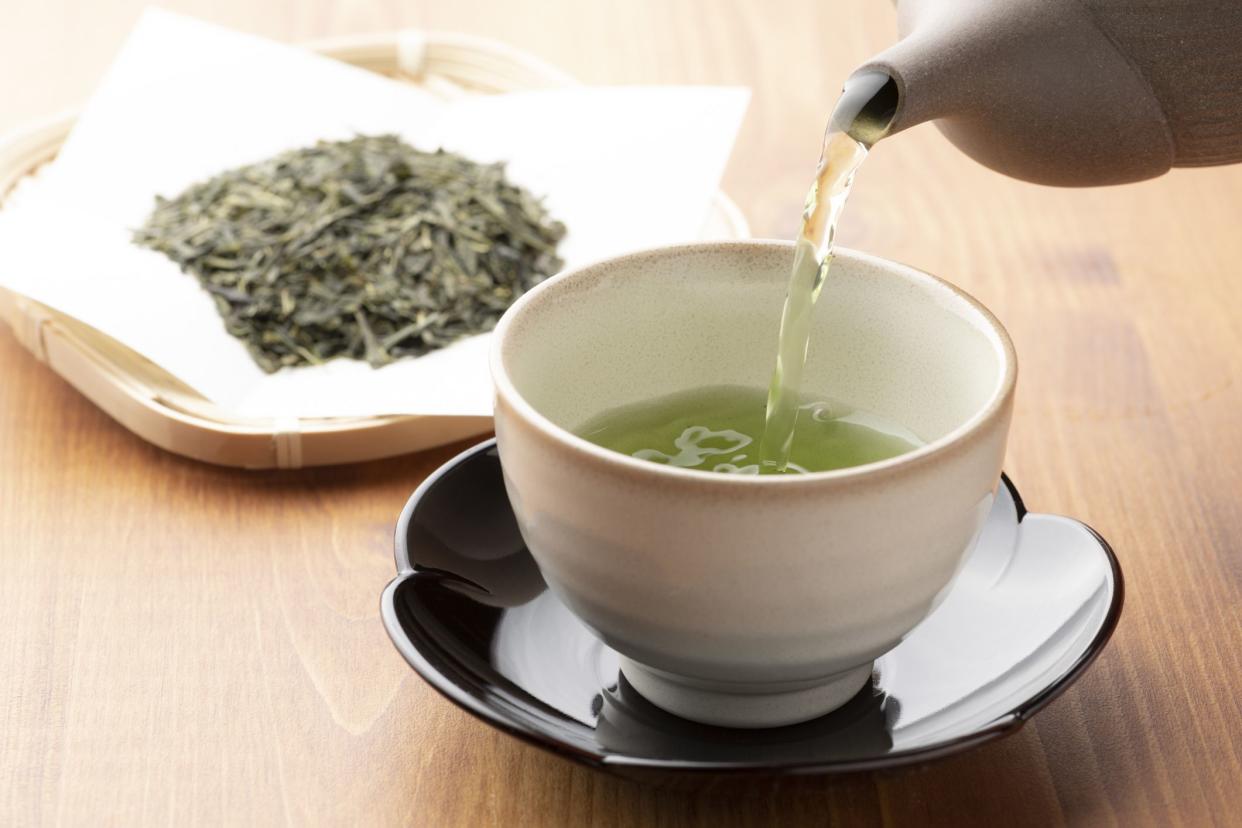 Warm green tea on a wooden table.