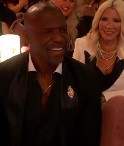 <p>CBS</p> Trevor Noah directs the camera to Terry Crews during a joke at the Grammys about Taylor Swift appearing on screen during NFL matches