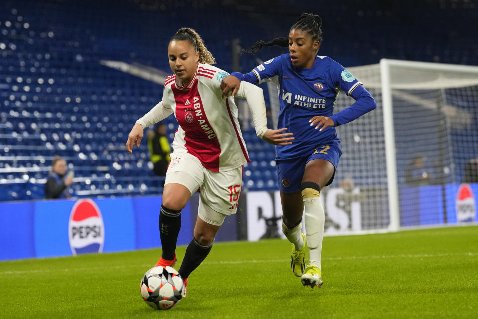 Ajax's Chasity Grant, left, is challenged by Chelsea's Ashley Lawrence during the Women's Champions League quarterfinal second leg soccer match between Chelsea and Ajax at Stamford Bridge Stadium in London, Wednesday, March 27, 2024. (AP Photo/Kirsty Wigglesworth)