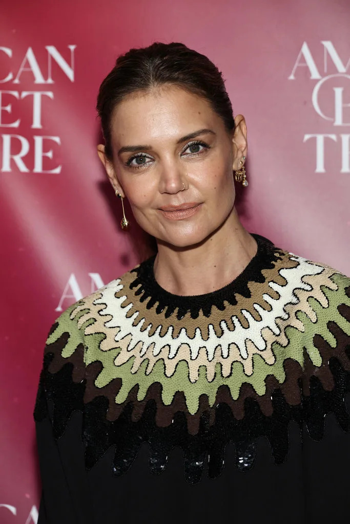 Katie Holmes at an American Ballet Theatre event in a black dress with intricate green and white textured detailing around the neckline