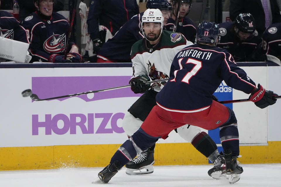 Arizona Coyotes defenseman Matt Dumba, rear, passes under pressure from Columbus Blue Jackets right wing Justin Danforth (17) during the second period of an NHL hockey game Thursday, Nov. 16, 2023, in Columbus, Ohio. (AP Photo/Sue Ogrocki)