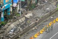 Soldiers walk past the gas explosions site in the southern Kaohsiung city on August 2, 2014