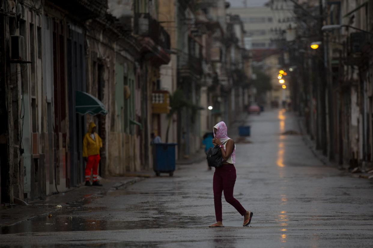 A pedestrian crosses an empty street during the passing of Hurricane Ian in Havana, Cuba, early Thursday, Sept. 27, 2022.