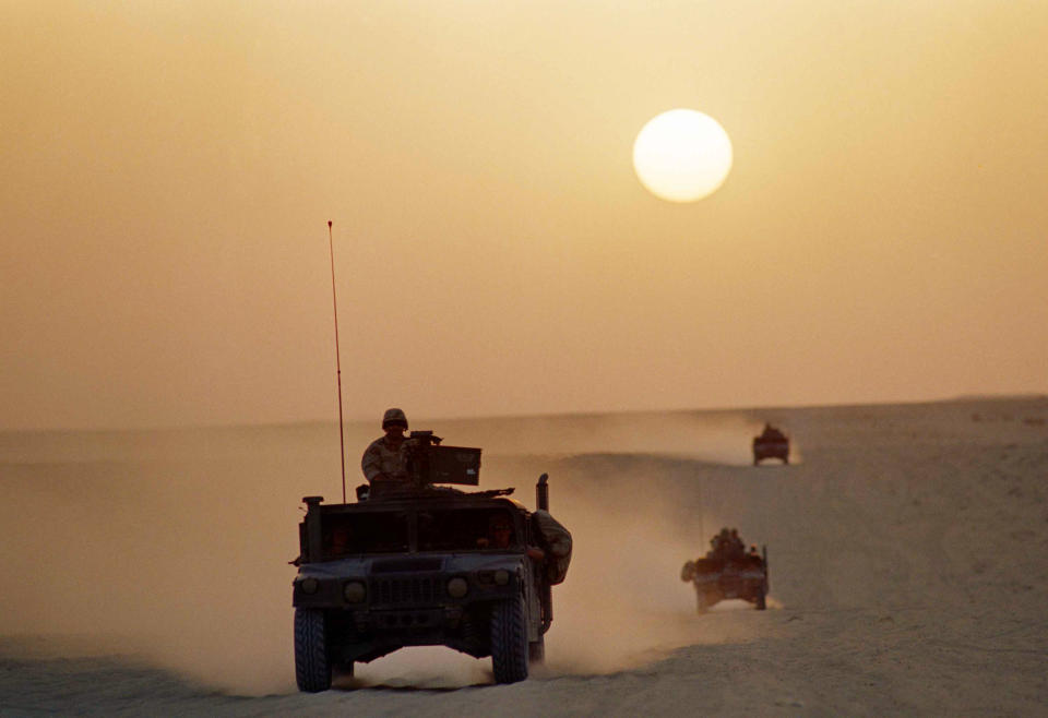 FILE - A group of Marine Humvees, deployed in forward positions as part of Operation Desert Shield, tear across the Saudi desert under a setting sun on Oct. 2, 1990 in Saudi Arabia. Former award-winning Associated Press photographer John Gaps III, who documented everything from war zones to the NCAA College World Series during his career, was found dead at his home Monday, Oct. 17, 2022, in Des Moines, Iowa, his family confirmed Tuesday. He was 63. (AP Photo/John Gaps III, File)