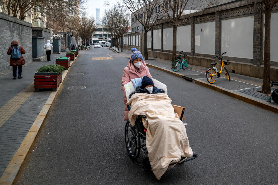 Dos personas se dirigen a una clínica para tratar la fiebre en un hospital de Pekín, donde ha habido escasez de medicamentos y kits de pruebas rápidas para la COVID-19, el 20 de diciembre de 2022. (Andrea Verdelli/The New York Times)
