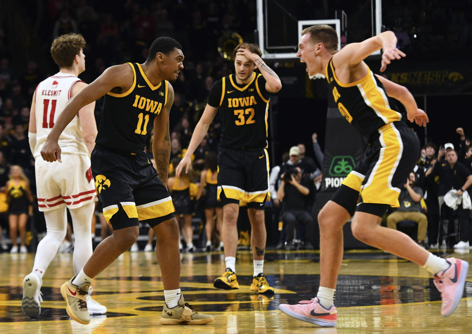 Iowa guard Tony Perkins (11) celebrates his game winning basket with forward Payton Sandfort (20) during overtime in an NCAA college basketball game against Wisconsin, Saturday, Feb. 17, 2024, in Iowa City, Iowa. (AP Photo/Cliff Jette)