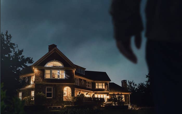 stranger stands outside a home in "the watcher"