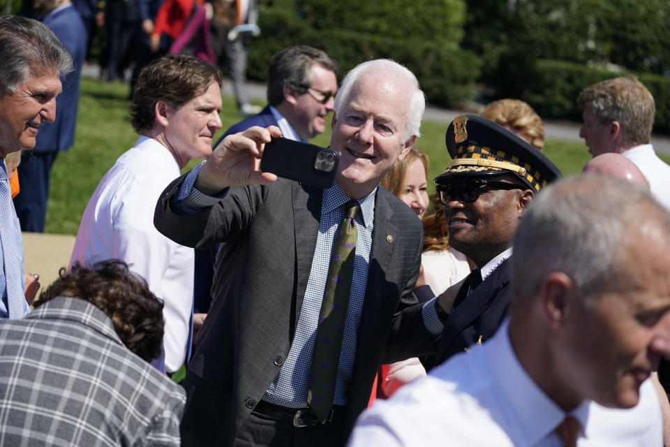 Sen. John Cornyn, R-Texas, takes a selfie as he arrives to an event to celebrate the passage of the "Bipartisan Safer Communities Act," a law meant to reduce gun violence, on the South Lawn of the White House, Monday, July 11, 2022, in Washington. (AP Photo/Evan Vucci)