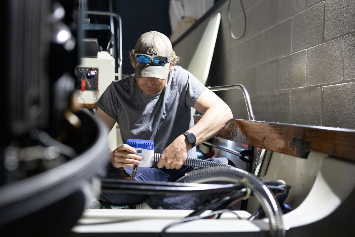 Dan Carmen, a local engine mechanic, works on an outboard engine in preparation for the summer on May 3, 2024.