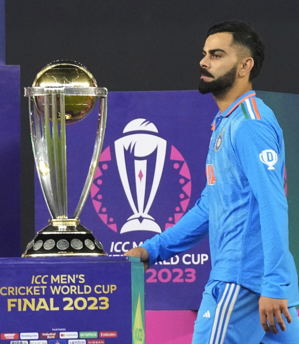 India's Virat Kohli walks past ICC Men's Cricket World Cup trophy to receive player of the tournament award after the final match against Australia, in Ahmedabad, India, Sunday, Nov.19, 2023. (AP Photo/Aijaz Rahi)