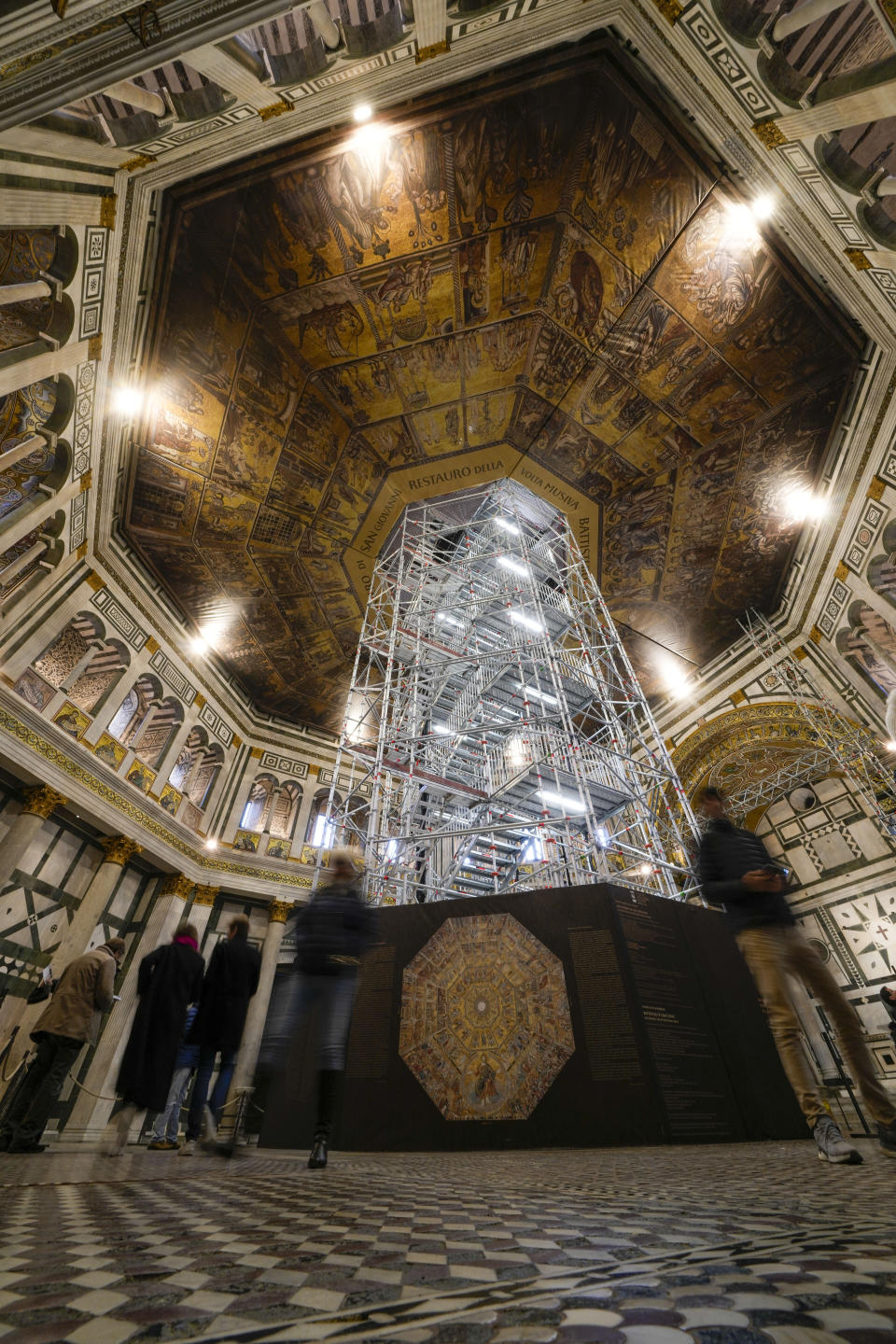 Visitors admire St. John's Baptistery, one of the oldest churches in Florence, central Italy, Tuesday, Feb. 7, 2023. The Baptistery's dome is undergoing a restoration work that will be done from an innovative scaffolding shaped like a giant mushroom that will stand for the next six years in the center of the church, and that will be open to visitors allowing them for the first and perhaps only time, to come come face to face with more than 1,000 square meters of precious mosaics covering the dome. (AP Photo/Andrew Medichini)