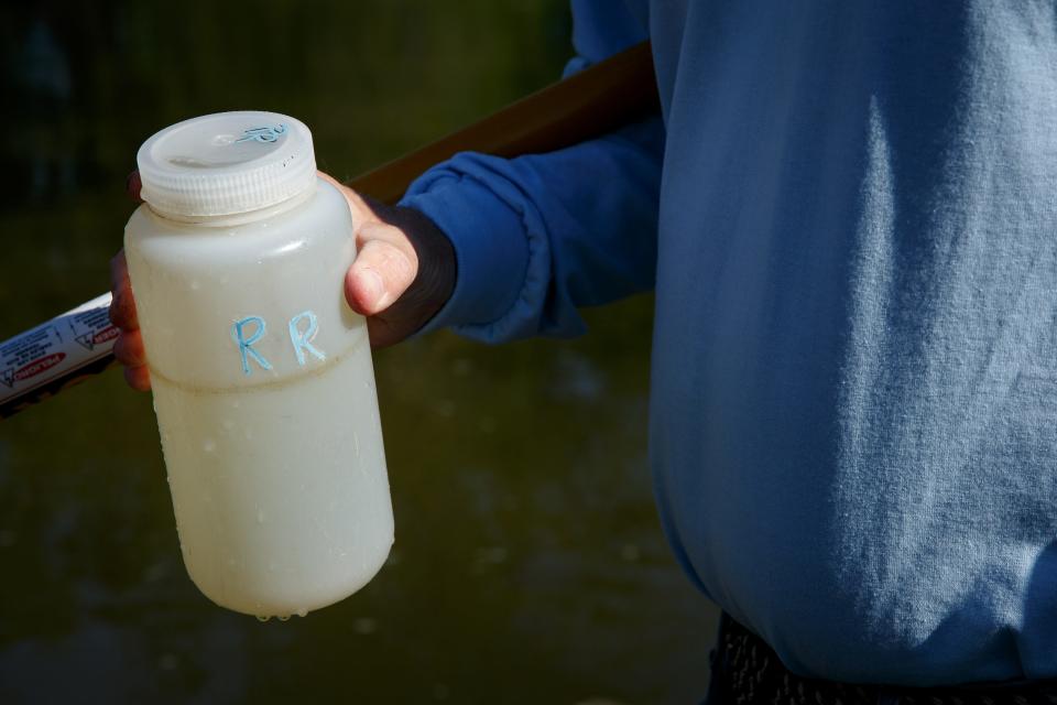 Des Moines Water Works Lab Tech Bill Blubaugh holds a sample of water from the Raccoon River in Water Works Park on Wednesday, May 12, 2021, in Des Moines.