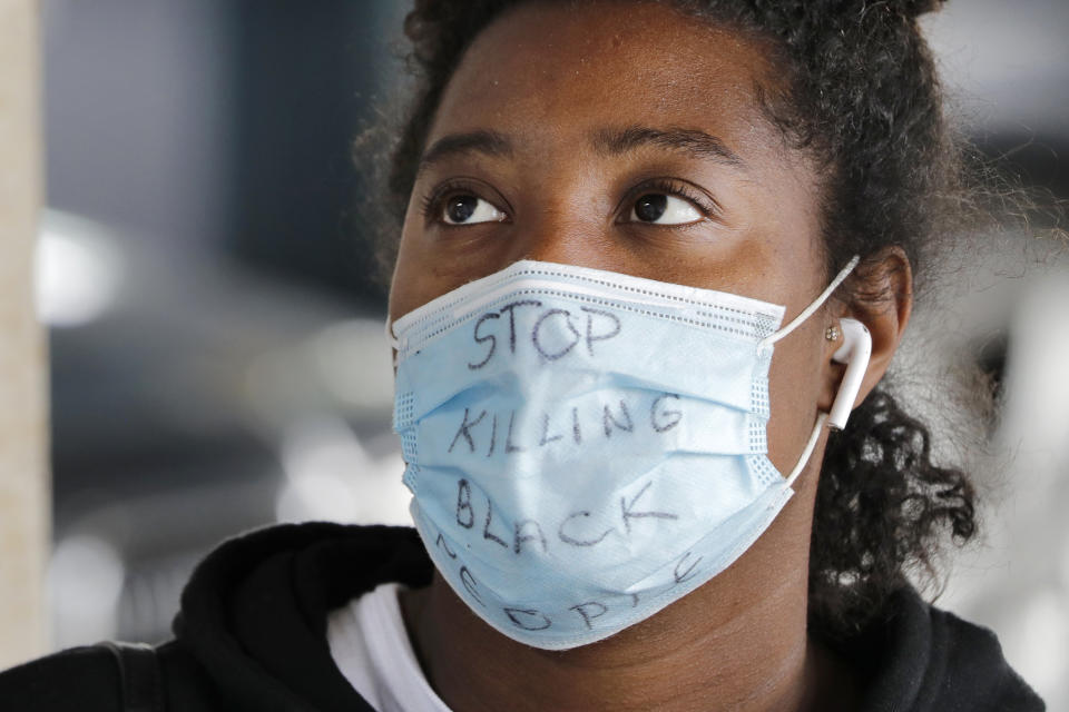 Nyasha Sarju listens as a Seattle Fire Department paramedic explains the procedure to take a nasal swab sample to test for coronavirus at a testing site Monday, June 8, 2020, in Seattle, after Sarju came in to be checked following her protesting over the past two weeks in the city. The new citywide testing program expanded testing criteria to include individuals who participated in demonstrations throughout the past week, where people who have been protesting the death of George Floyd, a black man who was in police custody in Minneapolis. (AP Photo/Elaine Thompson)