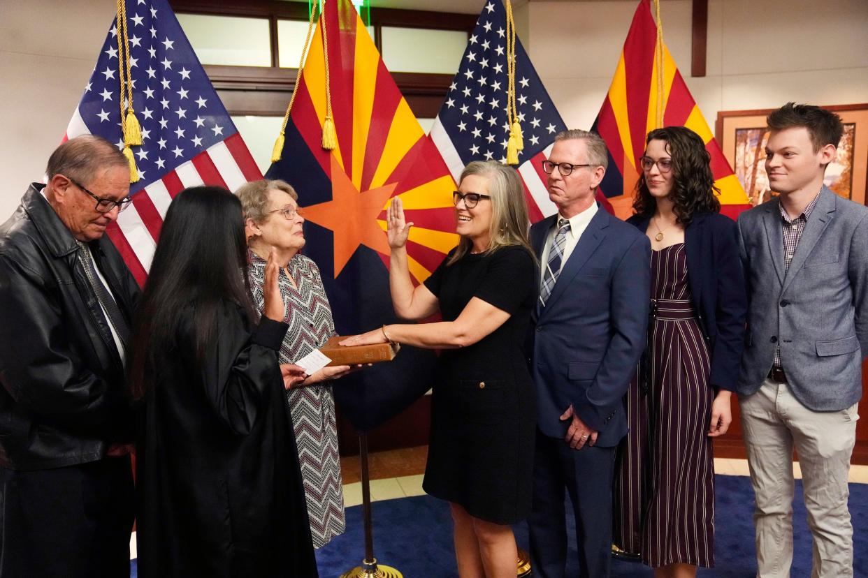 The new Arizona Democratic Gov. Katie Hobbs takes the oath of office in a ceremony as U.S. Circuit Judge for the Ninth Circuit Court of Appeals Roopali Desai (second from left) administers the oath while mother Linda Hobbs (third from left) holds the bible, and father John Hobbs (left), husband Patrick Goodman, (third from right), daughter Hannah and son Sam all look on at the state Capitol in Phoenix on Jan. 2, 2023.