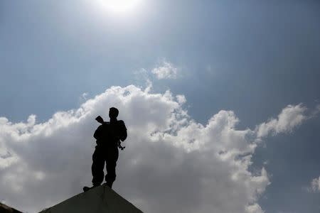 A Houthi militant stands on a wall as he secures a gathering for women loyal to the Houthi movement in Sanaa, Yemen September 5, 2016. REUTERS/Khaled Abdullah