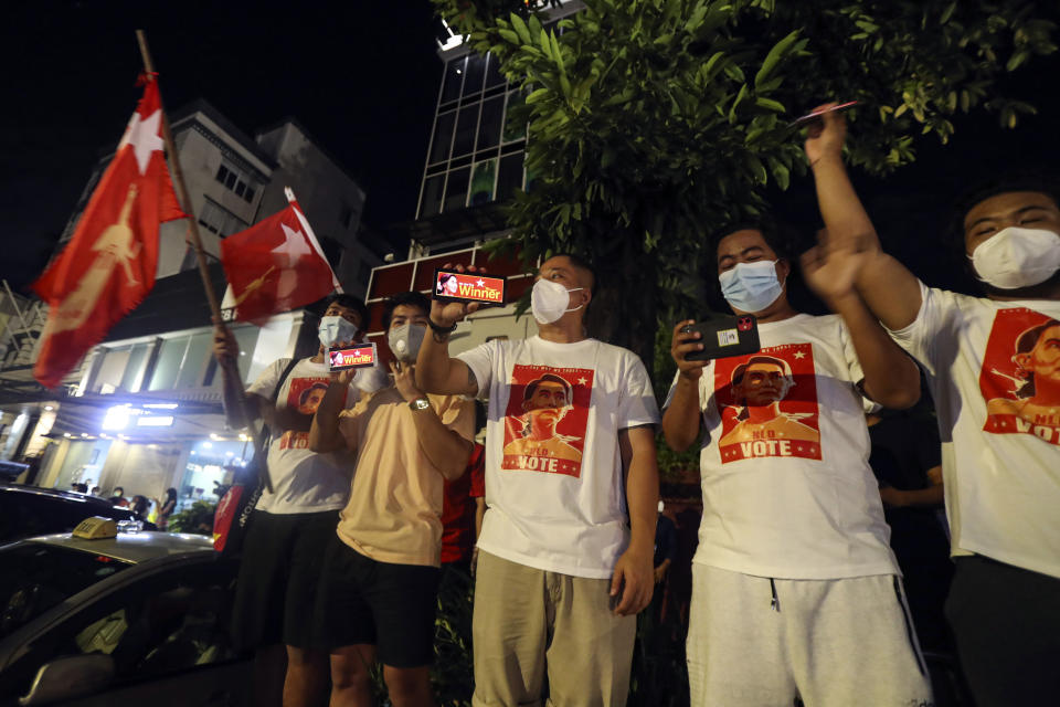 Supporters wearing face mask cheer as they gather in front of Myanmar Leader Aung San Suu Kyi's National League for Democracy (NLD) party's headquarters during Election Day Sunday, Nov. 8, 2020, in Yangon, Myanmar. (AP Photo/Thein Zaw)