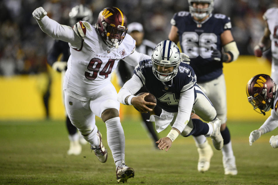 Dallas Cowboys quarterback Dak Prescott (4) leaping across with the ball to make the first down against Washington Commanders defensive tackle Daron Payne (94) during the first half an NFL football game, Sunday, Jan. 8, 2023, in Landover, Md. (AP Photo/Nick Wass)