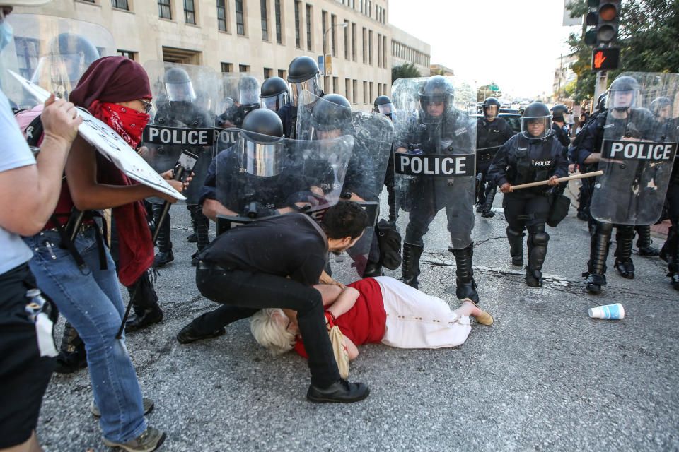 <p>A woman who was pushed down by police is helped by a protester while police try to desperse a crowd, after a not guilty verdict in the murder trial of Jason Stockley, a former St. Louis police officer, charged with the 2011 shooting of Anthony Lamar Smith, who was black, in St. Louis, Mo., Sept. 15, 2017. (Photo: Lawrence Bryant/Reuters) </p>