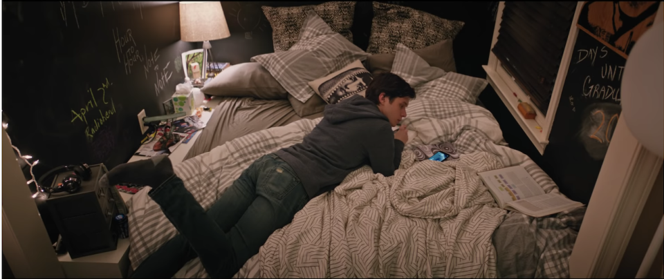 Simon in his bed surrounded by chalkboard walls