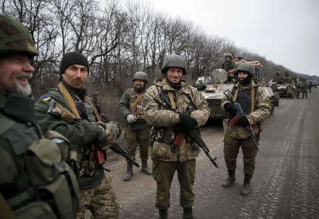 Members of the Ukrainian armed forces and armoured personnel carriers are seen preparing to move as they pull back from Debaltseve region, near Artemivsk February 26, 2015. REUTERS/Gleb Garanich