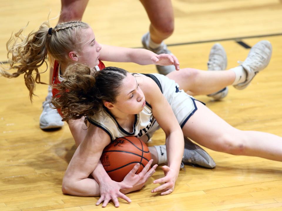 Granville's Katie Cottrell wrestles London's Cameron Markley for control of the ball during the Blue Aces' 52-18 victory against London in a Division II district semifinal at Ohio Dominican on Wednesday, Feb. 28, 2024.