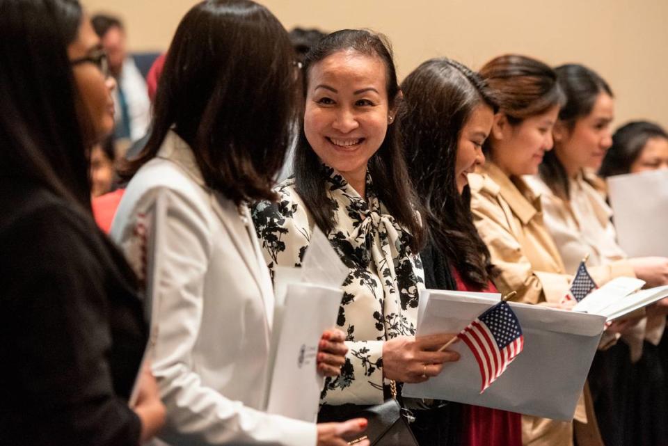 Newly naturalized American citizens congratulate each other during a naturalization ceremony at Dan M. Russell Courthouse in Gulfport on Thursday, Oct. 19, 2023.