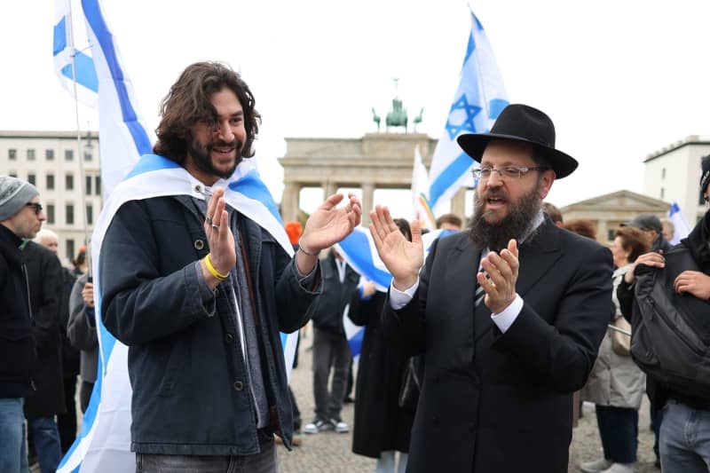 Rabbi Yehuda Teichtal (R) supports participants in the pro-Israel protest under the motto “Together against Hamas' crimes against Israelis and Palestinians,” marking the first anniversary of the October 7 attacks on Israel. Joerg Carstensen/dpa