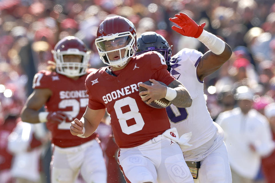 Oklahoma quarterback Dillon Gabriel (8) runs ahead of TCU linebacker Shad Banks Jr., background right, during the second half of an NCAA college football game Friday, Nov. 24, 2023, in Norman, Okla. (AP Photo/Alonzo Adams)