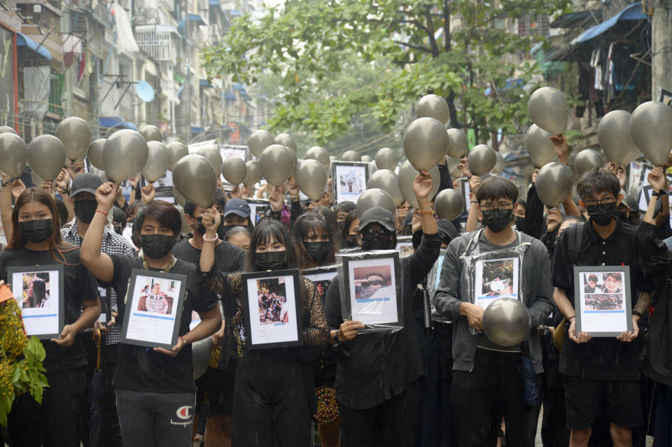 Anti-coup protesters holding pictures of those who died during a protest against the military offer prayers for them, in Yangon, Myanmar, Monday, April 5, 2021. Threats of lethal violence and arrests of protesters have failed to suppress daily demonstrations across Myanmar demanding the military step down and reinstate the democratically elected government. (AP Photo)