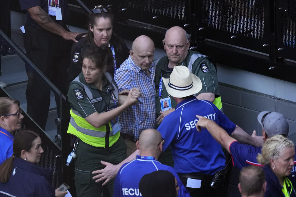 A spectator is assisted from Rod Laver Arena by medical staff during the semifinal between Novak Djokovic of Serbia and Jannik Sinner of Italy at the Australian Open tennis championships at Melbourne Park, Melbourne, Australia, Friday, Jan. 26, 2024. (AP Photo/Louise Delmotte)