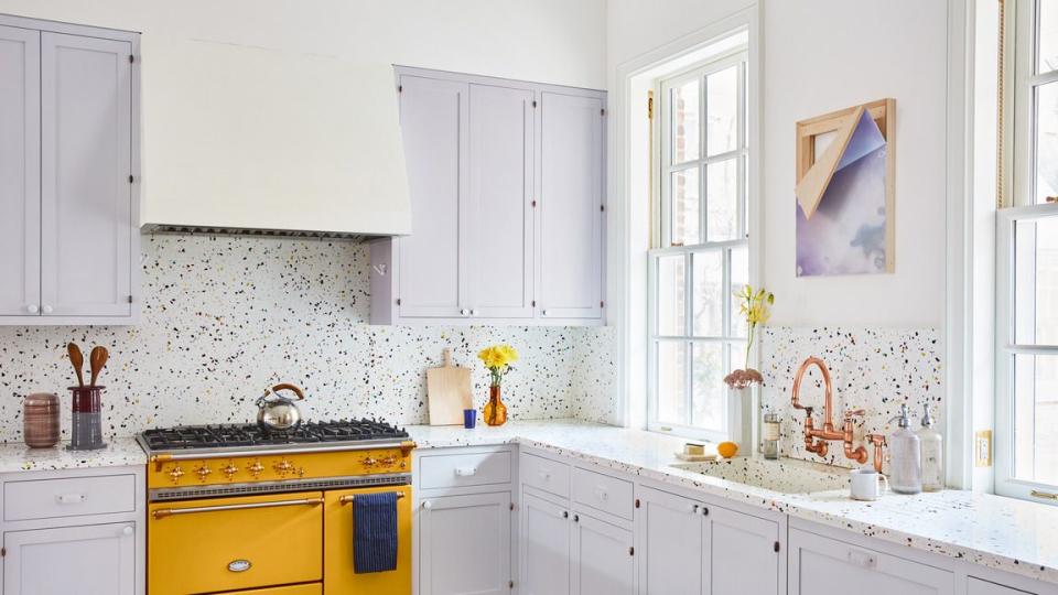 cabinets painted in soft and subtle calluna by farrow ball complement the citrus yellow lacanche range and rainbow terrazzo counters in this manhattan kitchen designed by penelope august