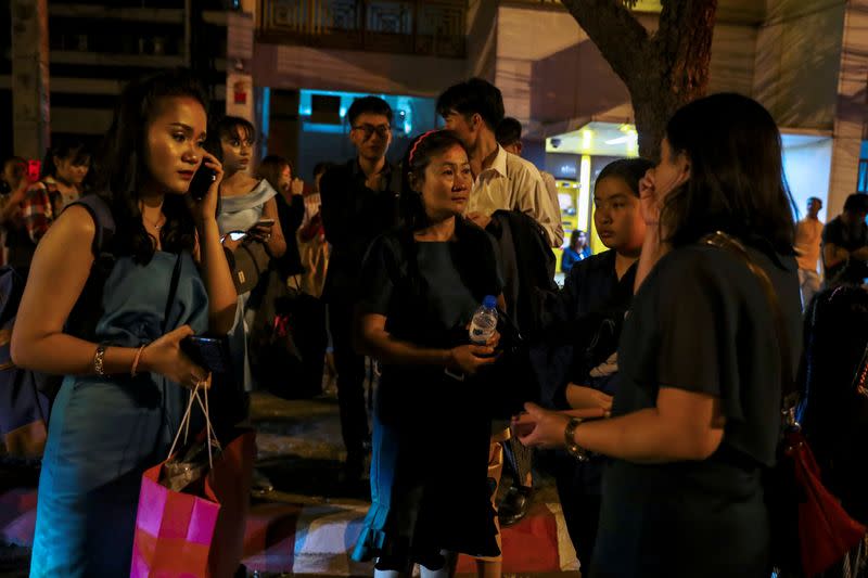 People who were evacuated from a shopping mall speak to each other after a mass shooting at the Terminal 21, in Nakhon Ratchasima